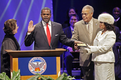 Kasim Reed being inaugurated, left, with father and mother. Courtesy ajc.com